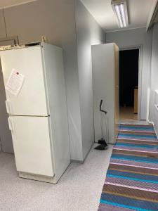 an empty room with a refrigerator and a hallway at Varastotie 1C in Ylivieska