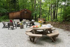 a picnic table and chairs with a barn in the background at Three Cabins - Pet Friendly & Hot Tub in Warren