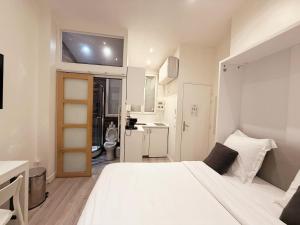 a bedroom with a large white bed and a bathroom at Rempart du Chateau-SV85 StudioVincennes in Vincennes