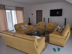 a living room with couches and a table and chairs at VILLA Keur Diam in Somone