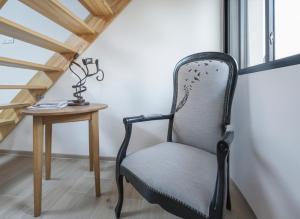 a chair next to a table and a window at le Gîte du Hibou in Rodemack