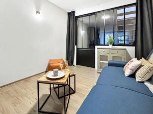 a living room with a blue couch and a table at le Gîte du Hibou in Rodemack