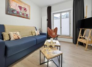 a living room with a blue couch and a table at le Gîte du Hibou in Rodemack