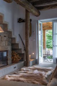 a living room with a stone fireplace and a glass door at SASSO AL MELO - Apartments in Cutigliano