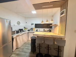 a large kitchen with a counter and a refrigerator at Fairyland private room in Port Louis +6 photos