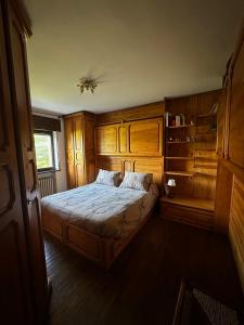 a bedroom with a large bed with wooden cabinets at Chalet Sofia in San Vito di Cadore