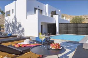 a villa with a pool and a table with a glass of wine at Villa Lambis Athena in Lindos