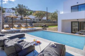 a swimming pool with lounge chairs next to a house at Villa Lambis Athena in Lindos