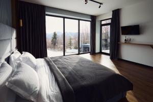 a bedroom with a large bed with a large window at Monte Blu in Migovo