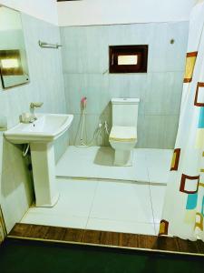 a bathroom with a toilet and a sink at Sunrich Beach Resort in Ilandaiyadi +18 photos