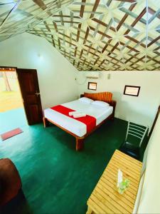a bedroom with a bed and a wooden ceiling at Sunrich Beach Resort in Ilandaiyadi