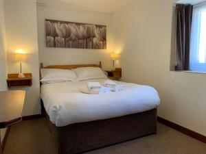 a bedroom with a bed with two towels on it at Low Costa Mill in Pickering +64 photos