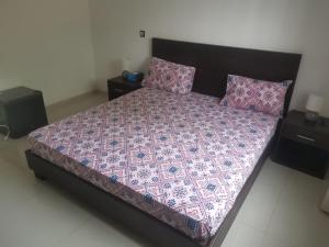 a bedroom with a large bed with a purple comforter at VILLA Keur Diam in Somone +5 photos