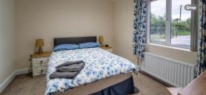 a bedroom with a bed and a window at Copperbeech Farm Cottages in Maze