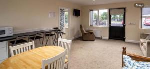 a kitchen and living room with a table and chairs at Copperbeech Farm Cottages in Maze
