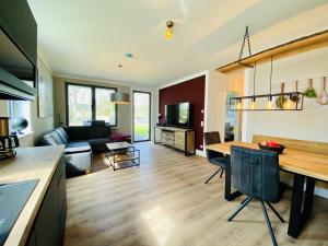 a kitchen and living room with a table and a couch at Ferienwohnung Auszeit in den Parkvillen Carlota und Candela Baabe in Baabe