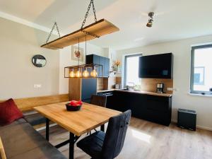 a living room with a dining room table and a kitchen at Ferienwohnung Auszeit in den Parkvillen Carlota und Candela Baabe in Baabe