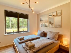 a bedroom with two beds and a window at Ferienwohnung Auszeit in den Parkvillen Carlota und Candela Baabe in Baabe