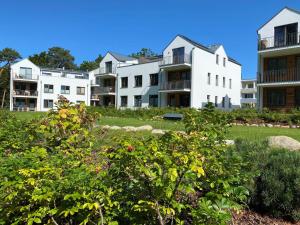 a row of white apartment buildings in a park at Ferienwohnung Auszeit in den Parkvillen Carlota und Candela Baabe in Baabe