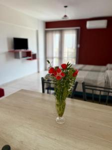 a vase with red flowers sitting on a table at Vanguardia Suites in San Juan