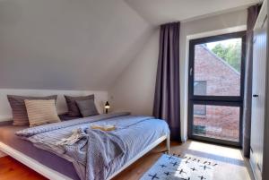 a bedroom with a bed and a large window at Ferienhaus Backsteinquartier D in Putbus mit Sauna und Kamin in Putbus