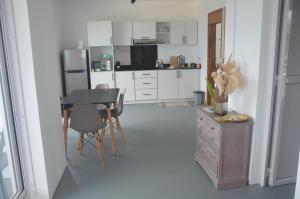 a kitchen with white cabinets and a table and chairs at Exceptional view! in Rivière Noire