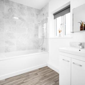 a white bathroom with a tub and a sink at Modern 2 Bed Apartment - Parking - Smart TV - Fast Wi-Fi 27CR in Sleightholme