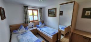 a small room with two beds and a mirror at Ferienwohnung Diechtler inkl. Chiemgaukarte in Ruhpolding