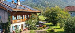 a person holding an umbrella in front of a house at Ferienwohnung Diechtler inkl. Chiemgaukarte in Ruhpolding