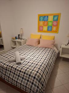 a bedroom with a bed with a checkered blanket at Eucalipto in Faro