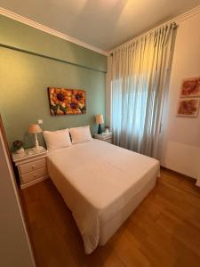 a bedroom with a bed and two night stands with two lamps at My apartment in Sacavém in Sacavém