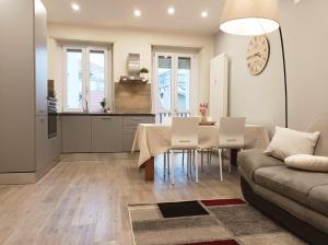 a kitchen and living room with a table and a couch at Quick Home - Edera in Biella
