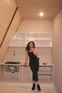 a woman in a black dress leaning against a counter at The triangle haven escape in Ani