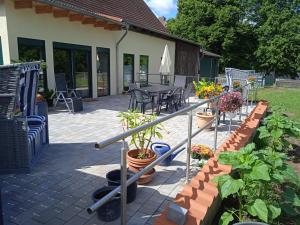 a patio with a table and chairs and plants at Wohnen am Schliestedter Bach b in Schöppenstedt