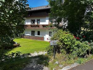 a large white house with a yard with a fence at Chalet Sofia in San Vito di Cadore