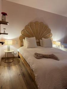 a bedroom with a large bed with a wooden headboard at le moulin de l oliveraie in Blausasc