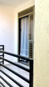 a balcony of a building with a window with a curtain at Muyenga Studio Apartments in Kampala