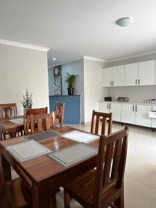 a kitchen and dining room with a wooden table and chairs at Pwake Luna Guesthouse in Swakopmund