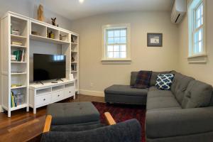a living room with a couch and a tv at Hike, Bike, & Explore: Vermont Family Farmhouse! in New Haven