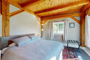 a bedroom with a large bed with a wooden ceiling at Hike, Bike, & Explore: Vermont Family Farmhouse! in New Haven