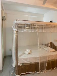 a bed in a room with a canopy bed at DEMITHA guest in Ranna
