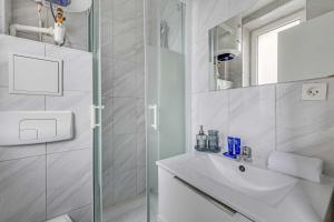 a white bathroom with a sink and a shower at Cosy Studio - 2P- Clichy in Clichy