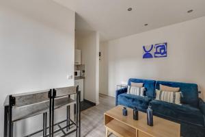 a living room with a blue couch and a table at Cosy Studio - 2P- Clichy in Clichy +1 photo