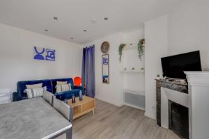 a living room with a fireplace and a tv at Cosy Studio - 2P- Clichy in Clichy