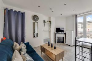a living room with a blue couch and a table at Cosy Studio - 2P- Clichy in Clichy