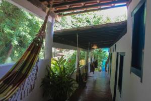 a porch with a hammock hanging from a building at Adios Amigos Hostel in Arraial d'Ajuda