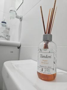 a bottle with sticks in it sitting on top of a toilet at Amplio Departamento Monoambiente in San Luis