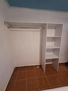 a closet with white shelves and a tile floor at Depa Banthi in San Juan del Río