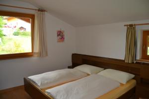 a bedroom with two beds and a window at Residence Rastbichl - Apartments & Indoor-Pool in Maranza