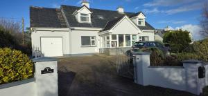 a white house with a car parked in the driveway at The Willows in Kerry in Tralee